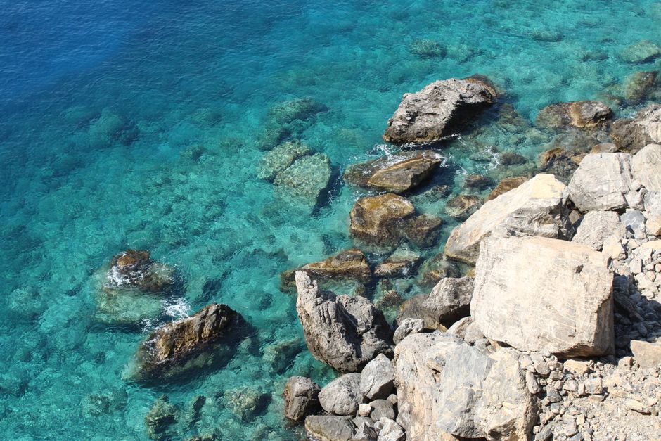 A breathtaking view of Greece's rocky coastline and clear turquoise sea.