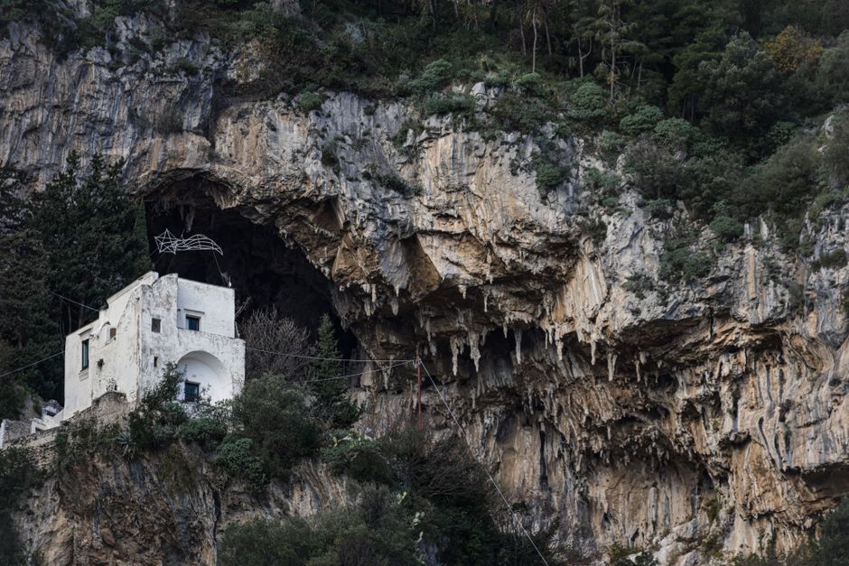 Picturesque white villa set in rugged cliffs of the Italian coastline, showcasing Mediterranean charm.