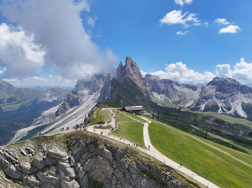 Breathtaking aerial view of Seceda mountain in the Dolomites, Veneto, Italy, under clear blue skies.