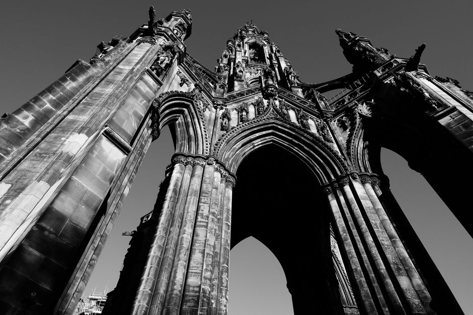 Striking black and white angle of an impressive Gothic architectural monument under a clear sky.