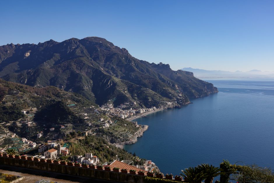 Breathtaking aerial view of the Amalfi Coast with rugged mountains and blue sea.