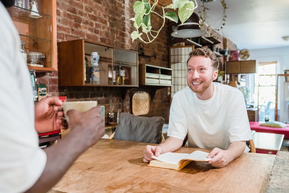 A friendly moment in a stylish cafe with a man reading a book and enjoying coffee.