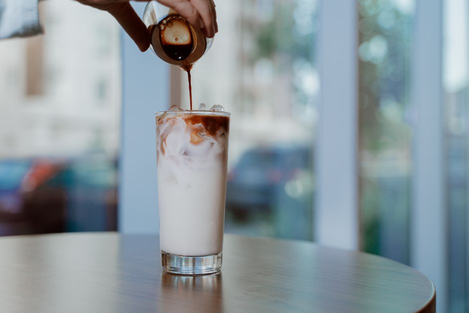 Close-up of iced coffee being poured into a glass, perfect for showcasing beverage freshness.