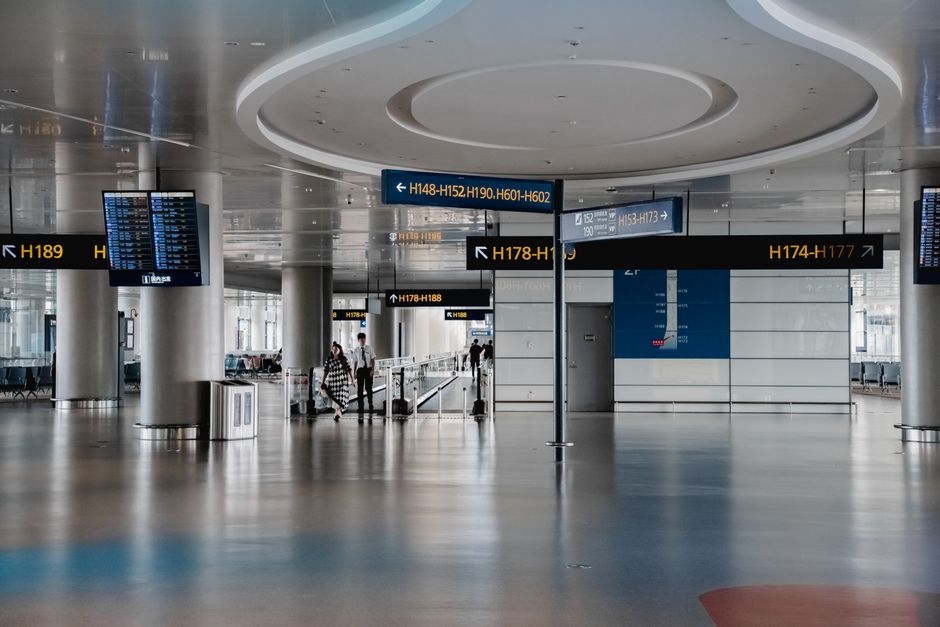 Spacious interior view of a modern airport terminal in Shanghai with signage and travelers.