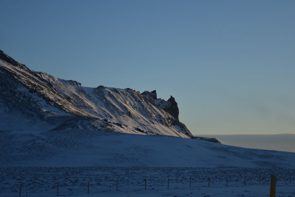 Snowy ridge illuminated by the first light of dawn under a clear sky.
