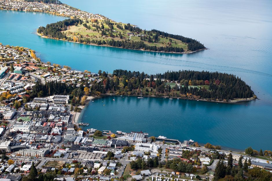 Stunning aerial view of a picturesque town by a lake, featuring lush islands and vibrant fall colors.