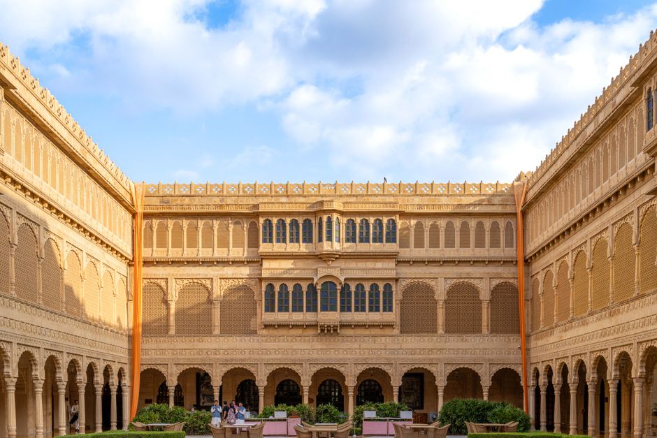 Exquisite courtyard of a heritage hotel in Jaisalmer, showcasing traditional Rajasthani architecture and ornate sandstone carvings.