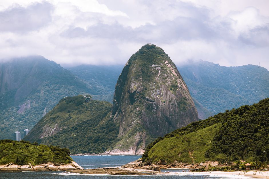 Breathtaking landscape of Sugarloaf Mountain shrouded in clouds, seen from Niterói, Brazil.