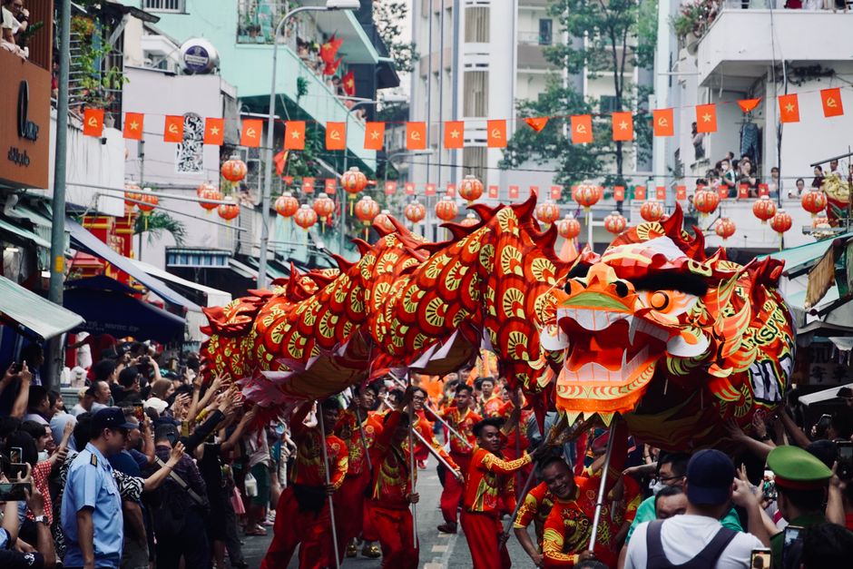 Colorful dragon dance during a bustling street festival in Asia celebrates cultural heritage.