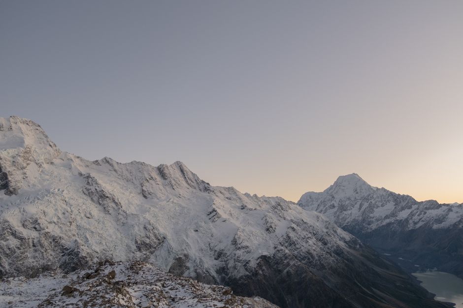 Capture the serene beauty of snow-covered peaks at dawn with this breathtaking mountain landscape photo.