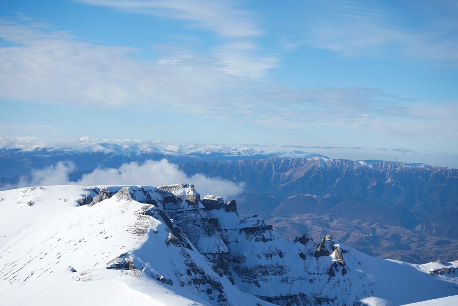 Breathtaking view of snow-capped mountain peaks beneath a vast blue sky.
