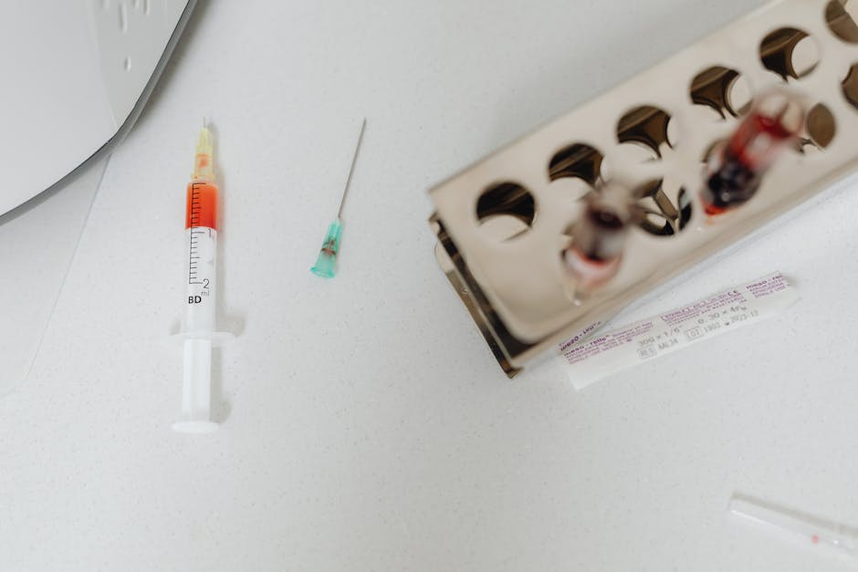 Syringe and needle with blood samples in a laboratory setting, capturing healthcare diagnostics.
