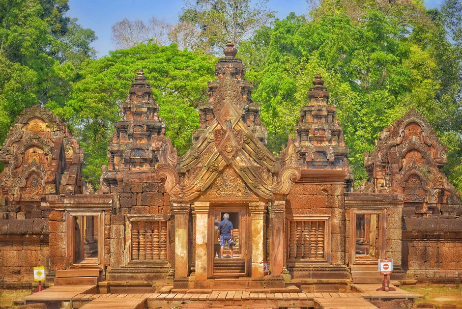 A visitor exploring the intricate architecture of the Banteay Srei Temple in Cambodia.