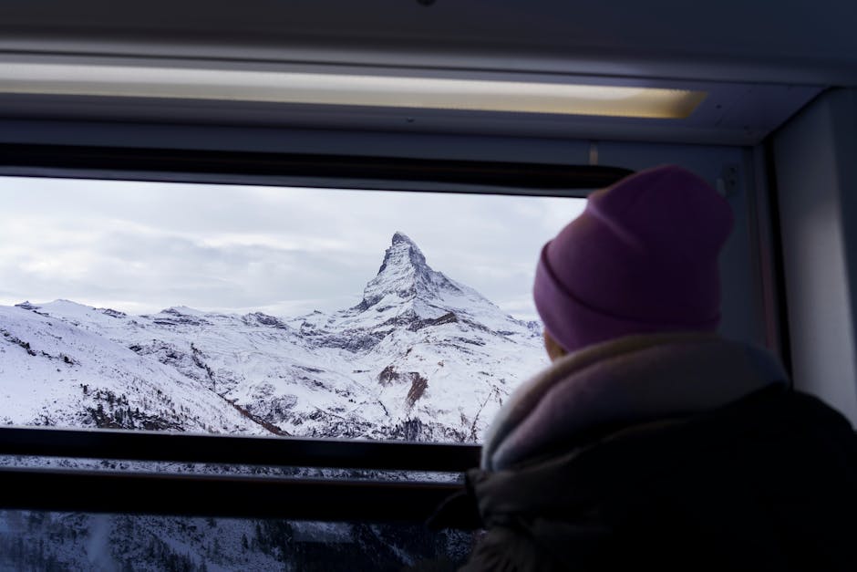 A scenic view of the Matterhorn with snow, seen from a train window.